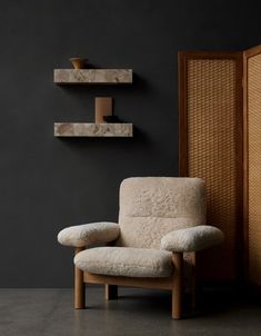 a white chair sitting in front of a wall mounted shelf