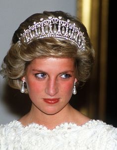 a woman wearing a tiara and earrings