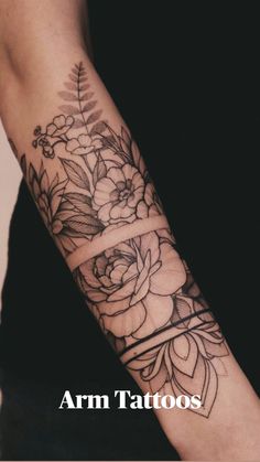 a woman's arm with flowers and leaves tattooed on the side of her arm