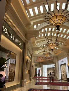 the interior of a luxury shopping mall with chandeliers hanging from it's ceiling