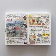 an open book with stickers on the pages and writing in korean characters inside it