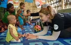 a woman is playing with children on the floor