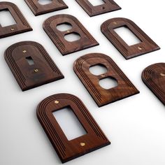 eight wooden switch plates are arranged in the shape of rectangles and ovales