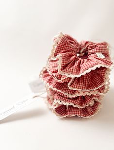 a stack of red and white ruffles on top of each other next to a measuring tape