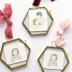 three framed pictures hang from gold frames with pink bows and ribbons on the top one has an ornament in the shape of a woman's head