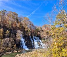 a large waterfall surrounded by trees and rocks