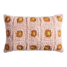 a crocheted pillow with an orange and yellow flower pattern on the front, sitting on a white background