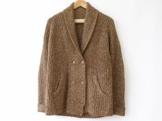 Brown tweed, ribbed knit, shawl collar cardigan by Zara. Cardigan has front pockets, double breasted button closure and corduroy elbow patches. Sweater is soft and not itchy. Condition/flaws: Cardigan is in overall excellent. Bottom ribbing appears to be stretched out so it has a bit of a loose fit. Also, front sides do not perfectly align at the bottom front centre (see photo). Fibre Content: 59% acrylic 27% cotton 14% nylon Garment Care: Hand wash, do not tumble dry, low iron, do not dry clean Zara Cardigan, Knit Shawl, Shawl Collar Cardigan, Brown Tweed, Sweater Fits, Collar Cardigan, Ribbed Knit Sweater, Elbow Patches, Low Iron