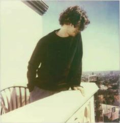 a young man standing on top of a building