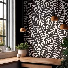 a room with some plants on the windowsill and a wall that has an intricate design