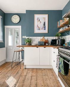 a kitchen with blue walls and wooden floors