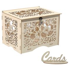 a wooden box with laser cut designs on the front and sides, sitting next to a card holder