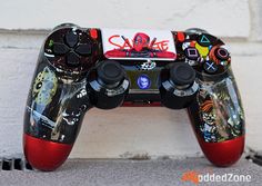 a close up of a video game controller on a brick wall with graffiti written on it