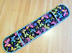 a black case with colorful flowers on it sitting on a wooden floor next to a cat toy