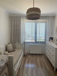 a bedroom with white furniture and wooden floors