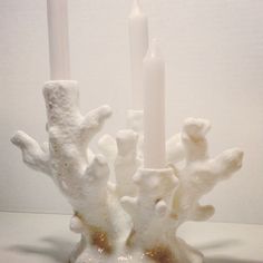 two white candles sitting next to each other on a table