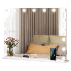 an image of a bed with lights on the headboard and pillows in front of it