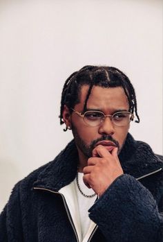 a man with dreadlocks wearing glasses and a jacket