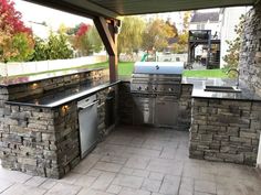 an outdoor kitchen with stainless steel appliances and grill