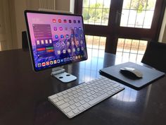 a computer monitor sitting on top of a wooden desk next to a keyboard and mouse