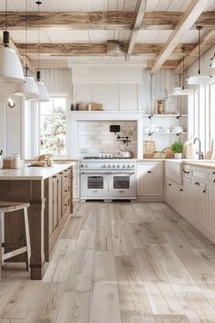 a large kitchen with white cabinets and wood flooring, along with an island in the middle