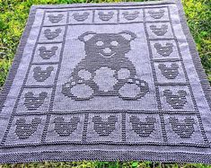 a crocheted teddy bear blanket on the grass