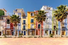 colorful buildings with palm trees in front of them