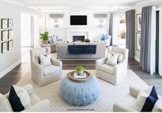 a living room filled with white furniture and blue accents