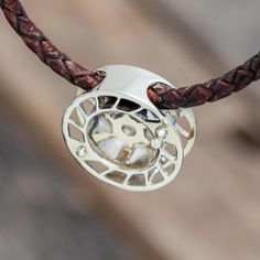 a leather cord with a silver pendant on it