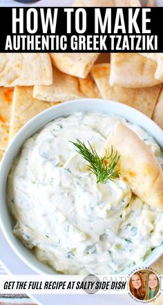 a white bowl filled with dip surrounded by pita chips and dill sprigs