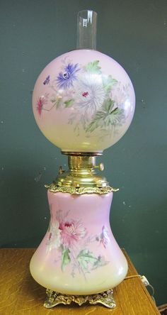 a pink and white lamp sitting on top of a wooden table