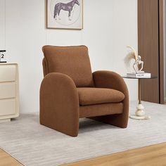 a brown chair sitting on top of a hard wood floor next to a white dresser