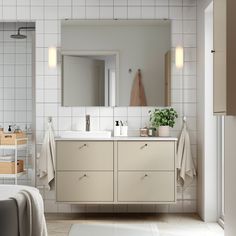 a bathroom with white tile and beige cabinets