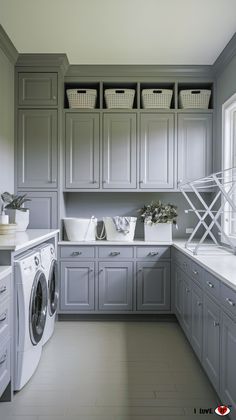 a washer and dryer in a room with gray cabinets, white counter tops and drawers