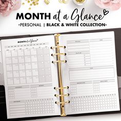 the month at a glance planner is open on top of a desk with pink flowers