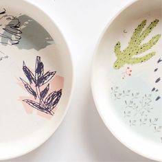 two bowls with designs on them sitting side by side