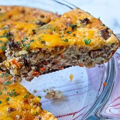 a slice of quiche in a glass pie dish with cheese and other toppings