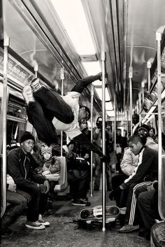 a group of people sitting on a subway car with their feet in the air,