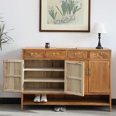 a wooden cabinet sitting next to a potted plant