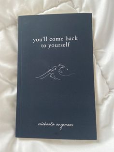 a book that is laying on top of a white sheet with the words you'll come back to yourself