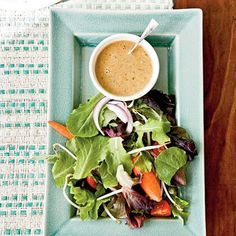 a green plate topped with salad and dressing