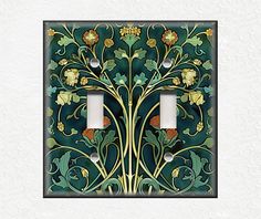 a decorative light switch cover with flowers and leaves painted on the wall in an art nouveau style