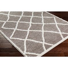 a gray and white rug on top of a wooden floor