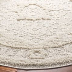 a large white rug on top of a wooden floor