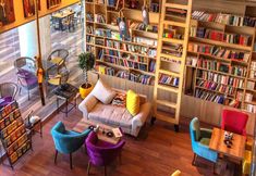 a living room filled with lots of furniture and bookshelves