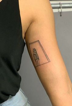 a woman's arm with a small tattoo of a person standing in front of an open door