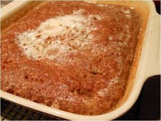 a square casserole dish with cheese in it sitting on a wire cooling rack