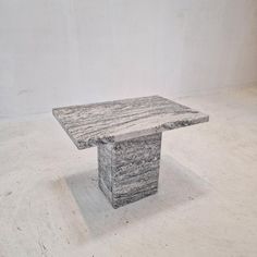 a stone table sitting on top of a white floor