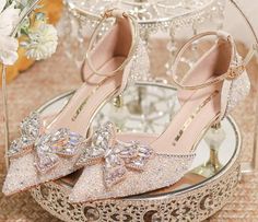 a pair of high heeled shoes sitting on top of a glass tray next to flowers