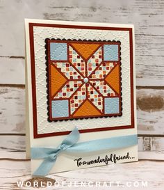 a handmade card with a quilted star on the front and blue ribbon at the bottom